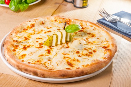 Pizza with pears and Gorgonzola cheese on the served wooden table. Selective focus, copy spaceの写真素材