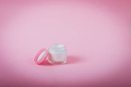 Opened Jar with face or body cream on pink background isolated. Beauty, make up, skincare concept. Selective focus, copy spaceの写真素材