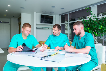 Group of medical staff discussing patient results in clinic. Healthcare professionals having...
