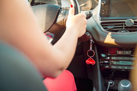 Car key in ignition. Start, stop or accelerate engine. Car shape keyfob on vehicle dashboard...