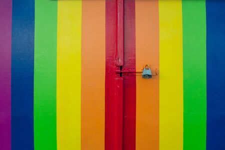 Colorful rainbow stripy door in LGBT flag colors with a padlock. Love Diversity under a ban, prohibited. Depicting the lack of right of same-sex marriage of homosexual couplesの写真素材