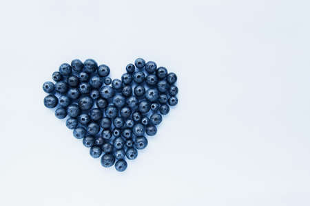 Superfood blueberries formed into a heart shape. Healthy food, summer berries. Minimal food concept. Flatlay. Selective focus. Copy space.の写真素材