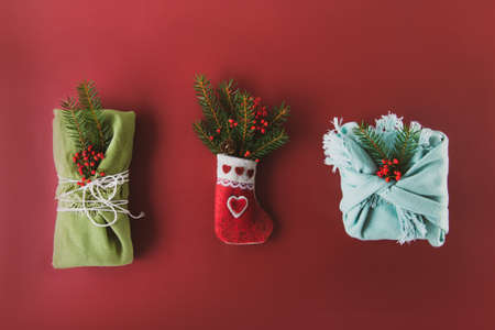 Festive Christmas composition of decorative felt sock with spruce branches and gift boxes wrapped in...