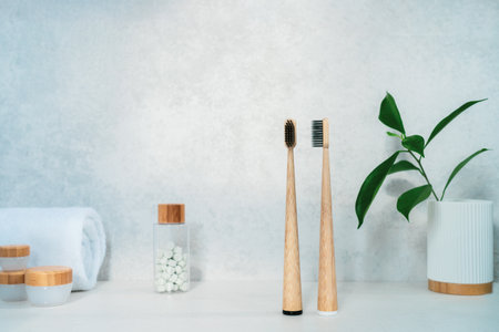 Zero waste bathroom items. Bamboo toothbrushes, natural mouth washing tabs, towel, creams in recycle tubes and green plant in the glass. Natural beauty essentials. Eco-friendly self-care. Copy spaceの写真素材