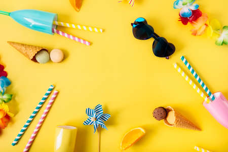 Top view flat lay of bright cocktail glasses with straws, Hawaii flower necklaces, sunglasses,...