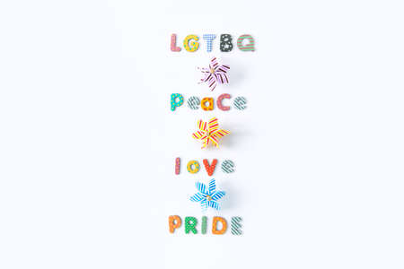 LGBTQ Peace love pride message made of multicolored letters with toy windmills on the white...