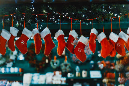 Hanging Advent calendar in form of hanging red stockings. Christmas decoration. Traditional festive decor on the blured background.の写真素材