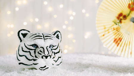 Tiger symbol and chinese bamboo paper fan with traditional chinese ornament. Chinese New Year of the Tiger 2022. Bokeh lights background. Wide banner. Copy space.の写真素材