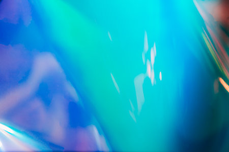 Photo texture of a fashionable holographic film. Abstract colorful holographic futuristic texture. Blurred emerald and blue backgroundの写真素材