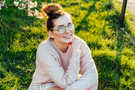 Portrait of young smiling caucasian hipster girl in glasses with pimples, acne on her face. Body positivity and diversity. Teenage skincare problems. Generation Z girl enjoy spring mood.の写真素材