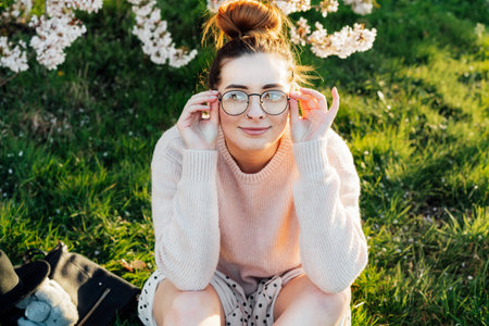 Portrait of young smiling caucasian hipster girl in glasses with pimples, acne on her face. Body positivity and diversity. Teenage skincare problems. Generation Z girl enjoy spring mood.の写真素材