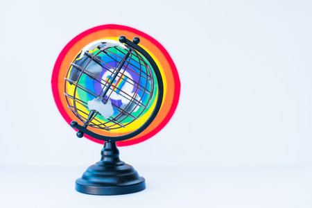 Metallic model of a globe with LGBT colorful rainbow background on the white. LGBTQIA Pride Month concept. Lesbian gay bisexual transgender. Gender equality. Human rights and tolerance. Copy space.の写真素材