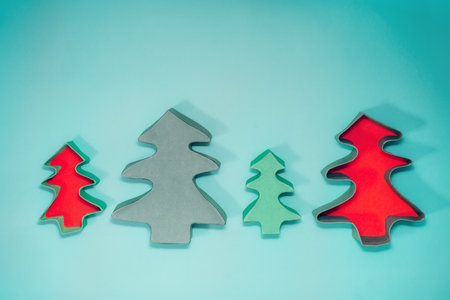 Top view empty Christmas gift boxes in the shape of Christmas trees on the turquoise background....
