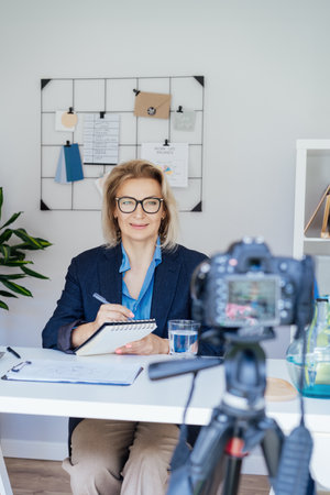 50s confident mature businesswoman, middle-aged experienced senior female professional recording...
