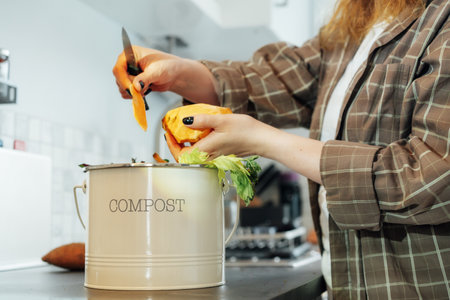 Compost the kitchen waste, recycling at home. Compost bin with vegetables cutted leftovers on the...