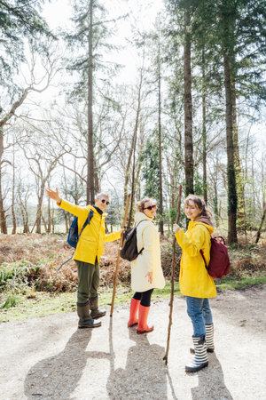 Group of friends walking with backpacks in forest. Trekking travel in adventure lifestyle, nature hiking in vacation holiday with journey. Tourism, hiking, and friendship concept. Outdoor activitiesの写真素材