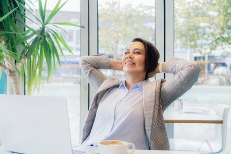 Relaxed happy 50s mature businesswoman, middle-aged experienced female feeling satisfied with done job rejoicing, got good news, overjoyed motivated lady received good results while working on pcの写真素材
