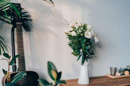 Modern minimalist style interior with modern hand-shaped vase with eustoma flowers, candles on a...