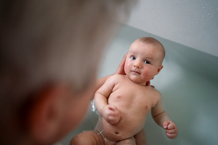 Top view cute baby bathing and swimming in the bath. Baby learning to swim and playing sports....
