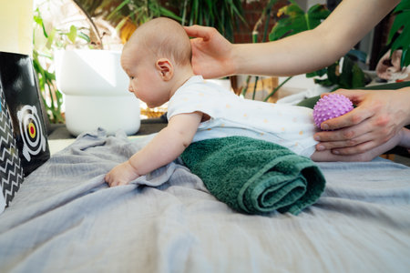 Father massages baby with massage ball. Healthy massage. Sensory tactile activities. Children...