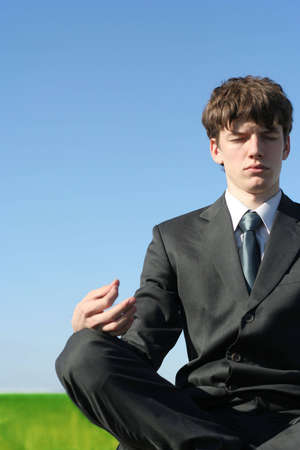 young successful businessman sitting in meditation poseの写真素材