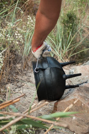 Hand holding a cast iron potの写真素材