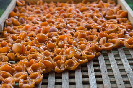 Close-up of sliced  apricots on wooden tray. Background of dried fruit.