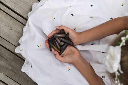Little girl holding rifle bullets shell in her hands.