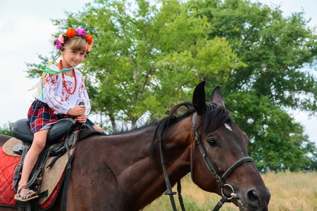 A girl in Ukrainian traditional clothes on horsebackの写真素材