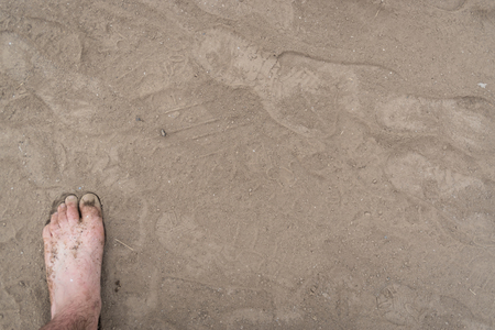 Male foot on dusty dirty ground. Top view, close-upの写真素材