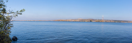 Panorama. Beautiful natural autumn landscape on the Dnieper river and green island on blue sky backgroundの写真素材