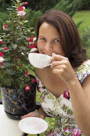 Portrait of the beautiful woman sitting in a garden の写真素材