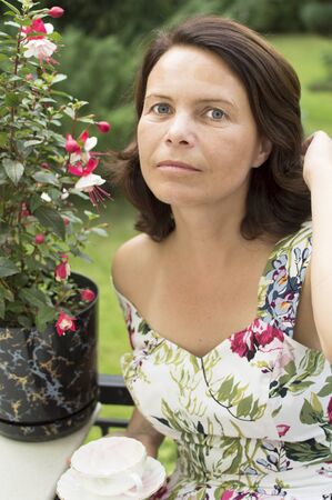 Portrait of the beautiful woman sitting in a garden の写真素材