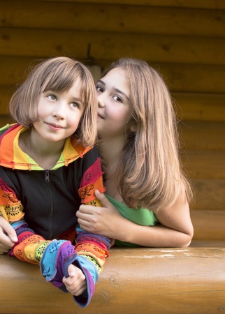 Girls are photographed on a balcony of the wooden house の写真素材