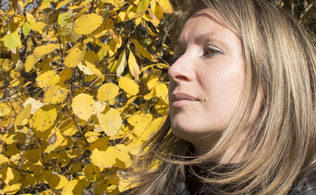 Portrait of the woman against autumn leaves の写真素材