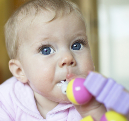 The baby of half a year sucks a toy の写真素材