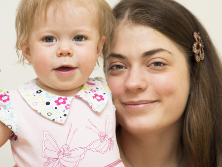 Young mother and the daughter of 11 months old is looking directly の写真素材
