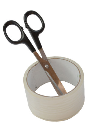 scissors with a black handle inserted into a skein of adhesive tapeの写真素材