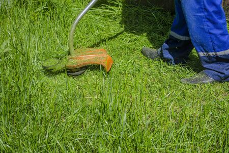 Man mows electric grass high lawn grass