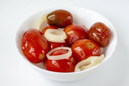 Pickled red tomatoes on a white plate. Selective focus.の写真素材