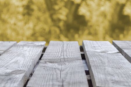 Background from a table made of boards with a view of orange blurred foliageの写真素材