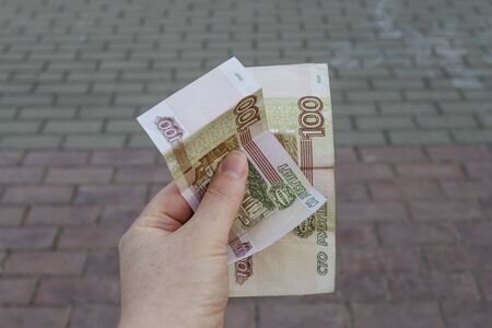 Two Russian bills in a female hand. Expenditures, debts.の写真素材
