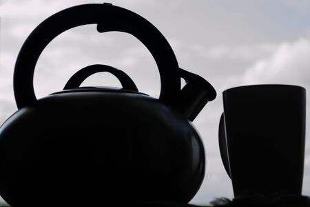Silhouette of a teapot and mug against the skyの写真素材