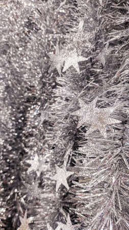 Silver Christmas tinsel with stars. Background, texture, Christmas