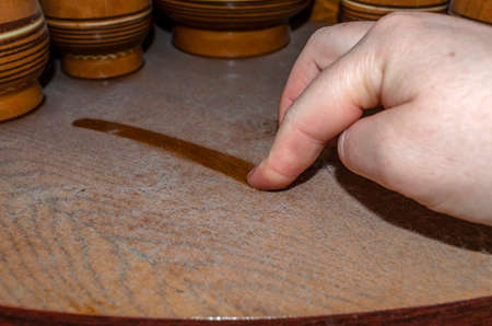 A woman holds her finger along a thick layer of dust on a wooden shelf. Allergen in the apartmentの写真素材
