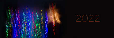 Abstract background of Christmas lights with long exposure. Colorful 2022 number on black backgroundの写真素材
