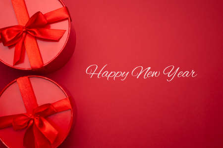 Two red gift boxes on a red background. Festive background for your design. Happy new year. Holiday concept.の写真素材