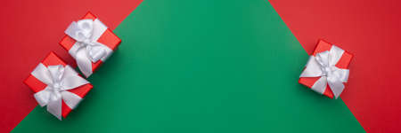 Celebratory red and green background with three gift boxes. Christmas background with copyspace....
