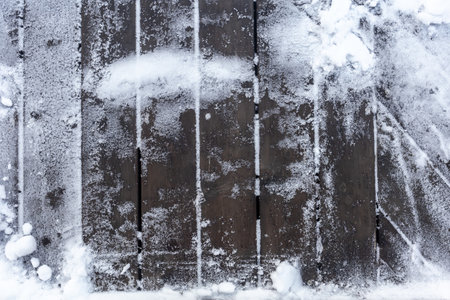 Surface of wooden planks under snow in winter. Top view.