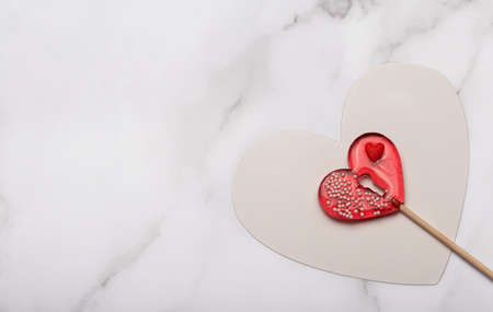 Heart shaped lollipops on white marble background. Candy Love concept. Valentine's Day.の写真素材
